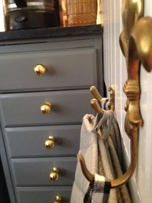 Labaro knopp i matt mässing på grå byrå.